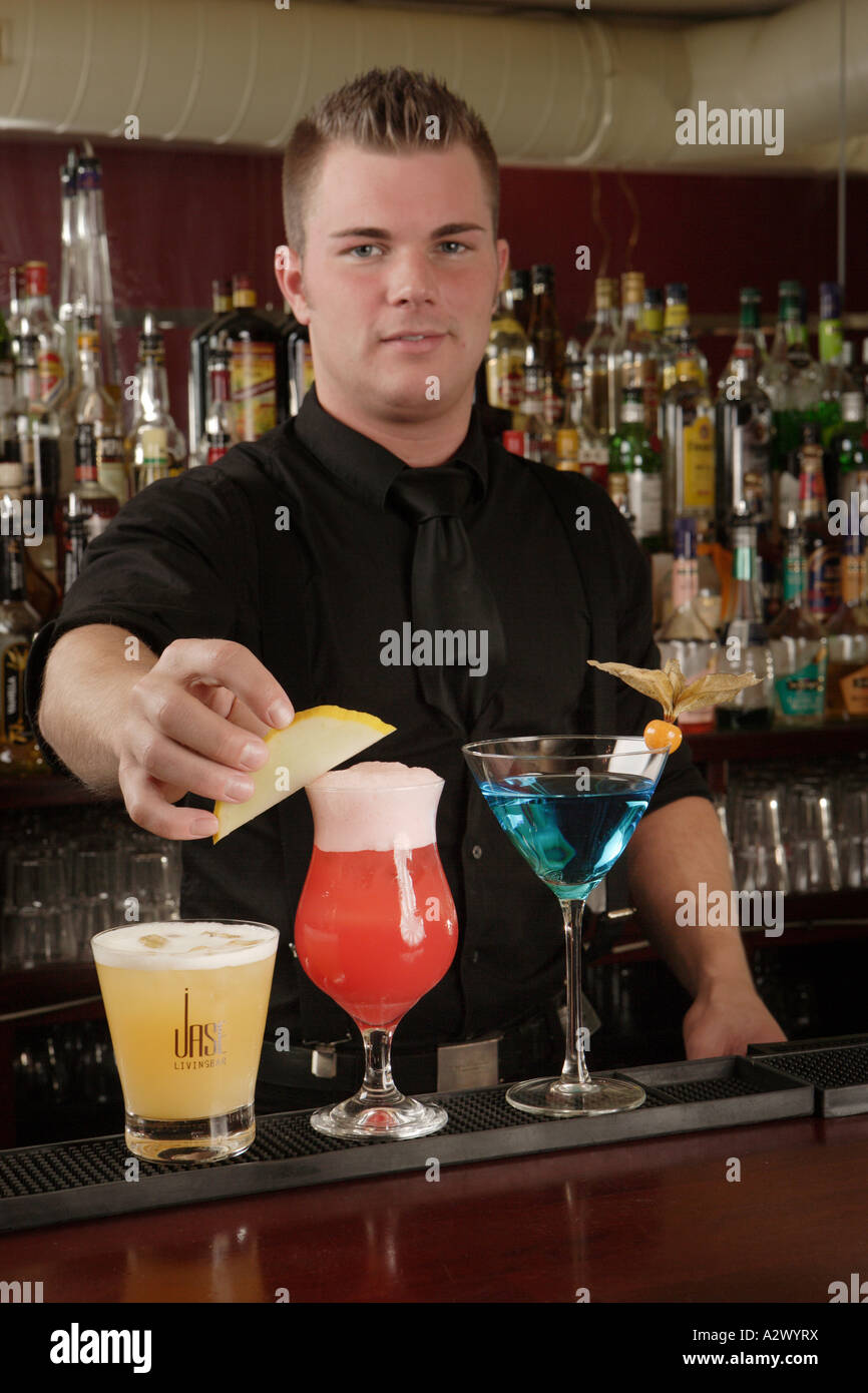 Barman prepares a Planters Punch The Cocktails from the left Whiskey Sour Planters Punch Blue Lady Stock Photo