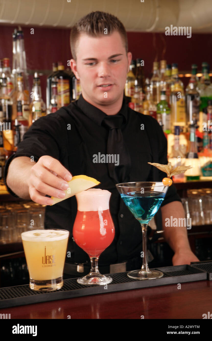 Barman prepares a Planters Punch The Cocktails from the left Whiskey Sour Planters Punch Blue Lady Stock Photo