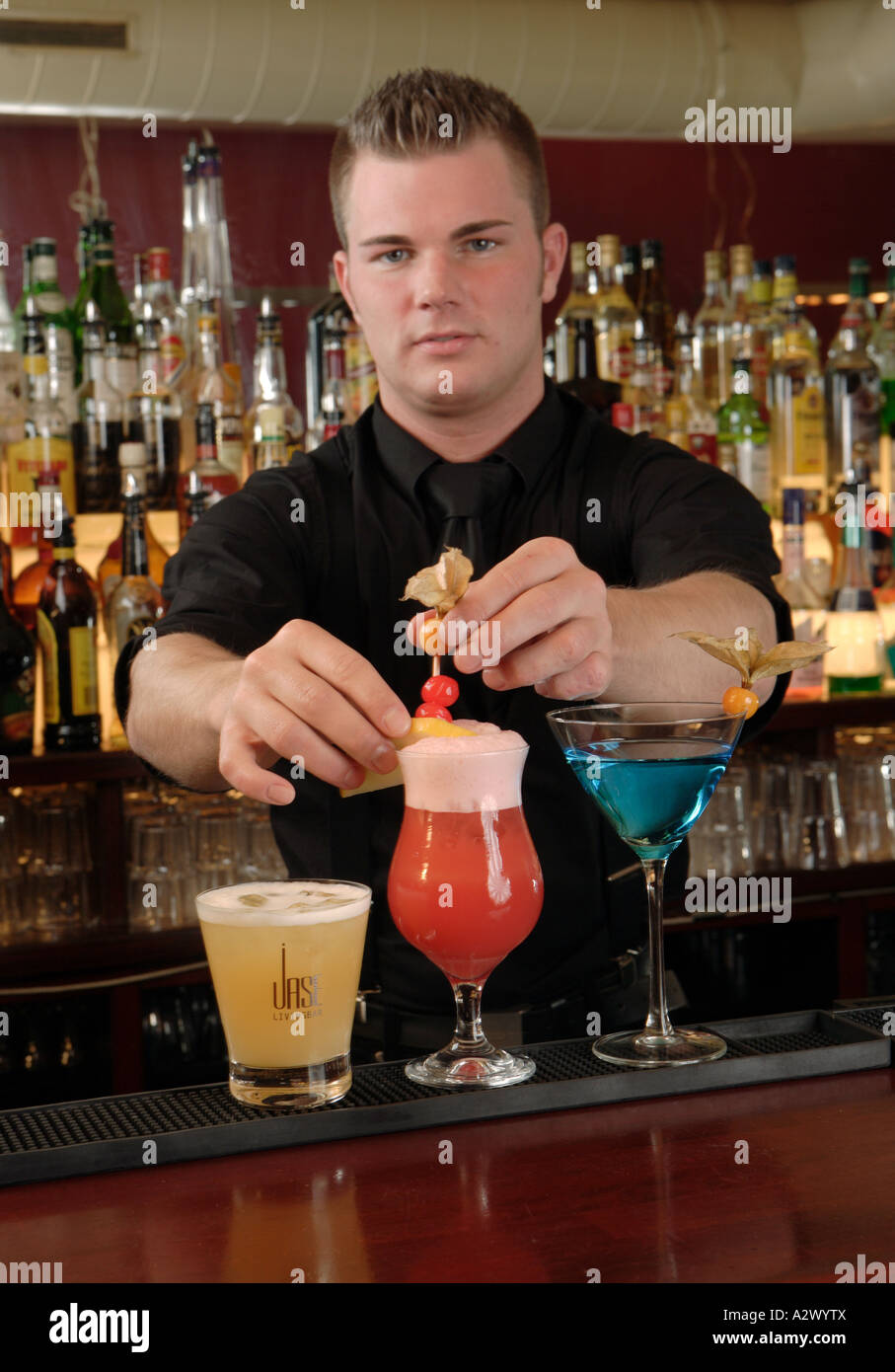 Barman prepares a Planters Punch The Cocktails from the left Whiskey Sour Planters Punch Blue Lady Stock Photo