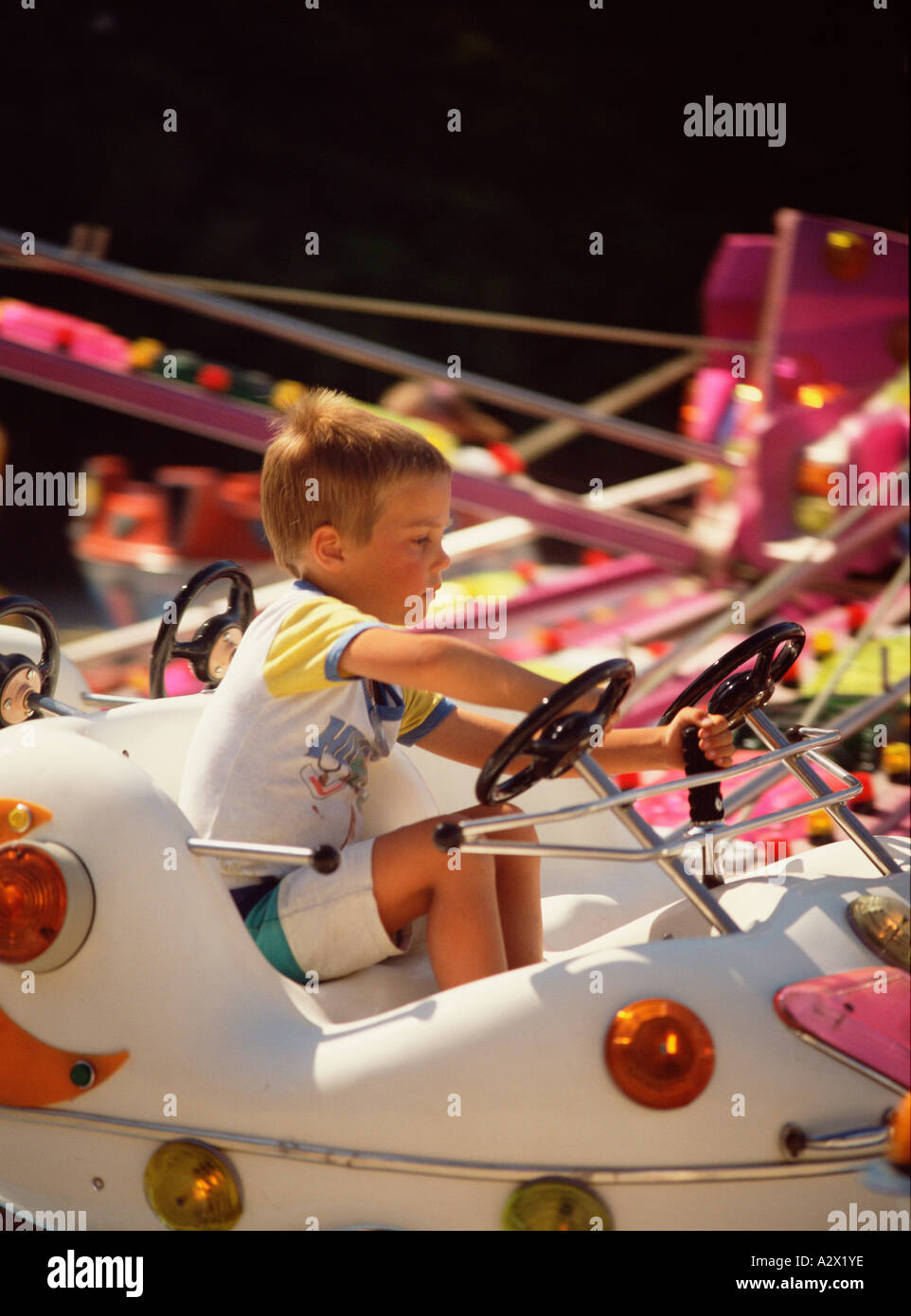 Children. Little boy sitting on Funfair ride car. Stock Photo