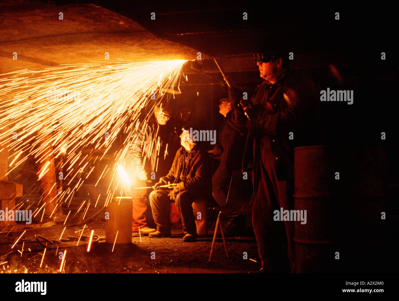 United Kingdom. Men working in ship building yard welding with oxyacetylene torch. Stock Photo