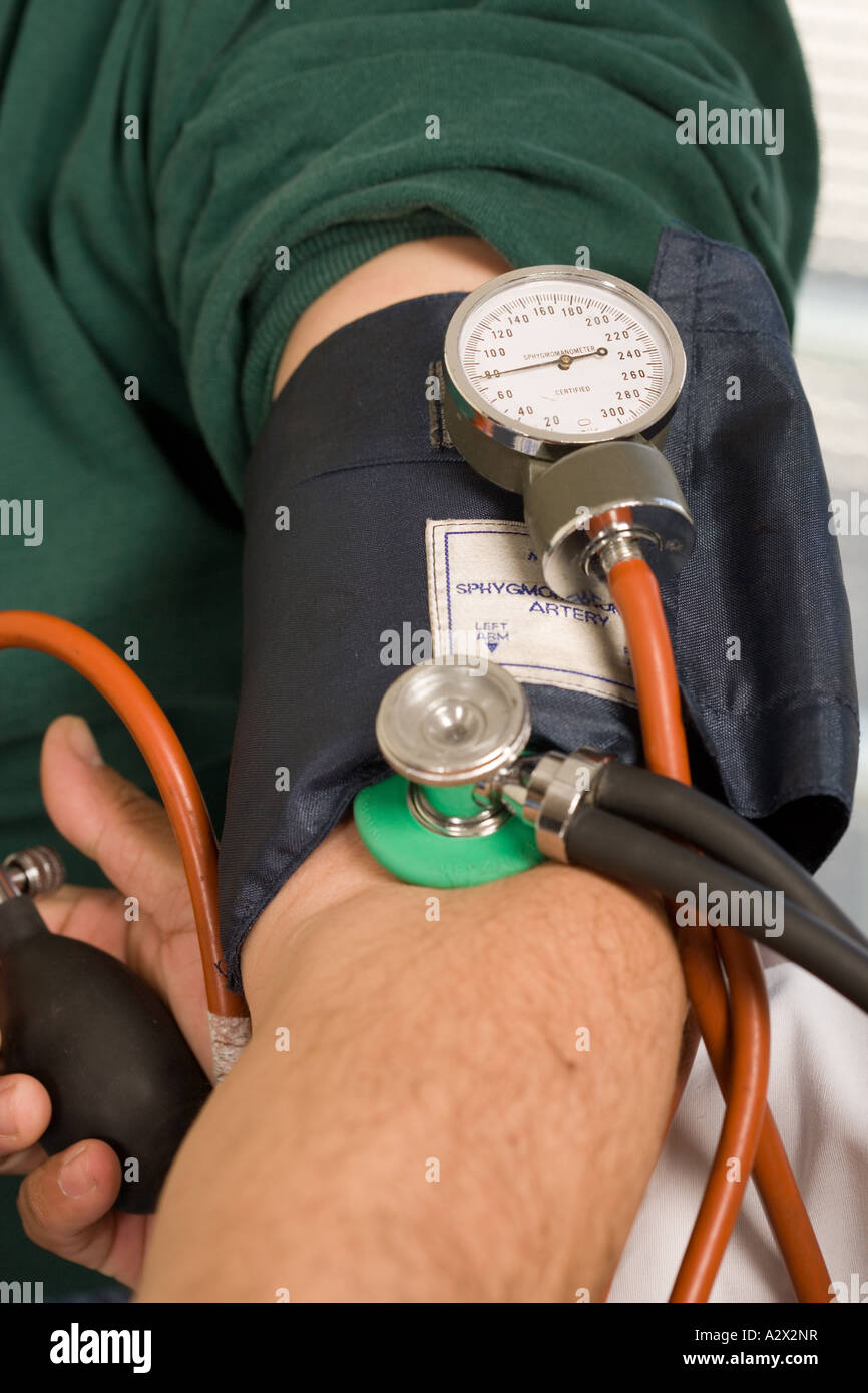 Blood pressure cuff on patients arm during an exam measuring blood pressure Stock Photo Alamy