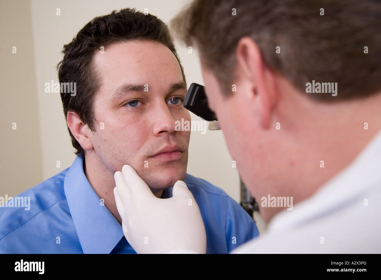 Doctor using a hand held ophthalmoscope to examine the patient's eyes Stock Photo Alamy