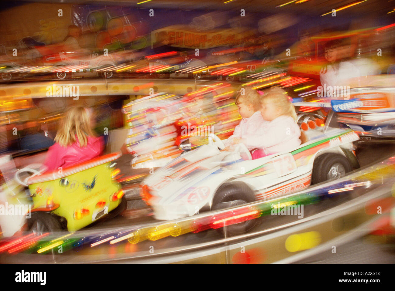 Children in cars of funfair roundabout ride. Stock Photo