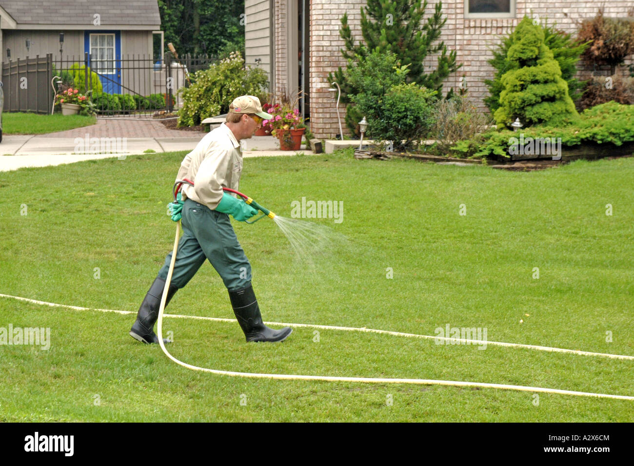 Professional Lawncare Maintenance man sprays weed and feed on a