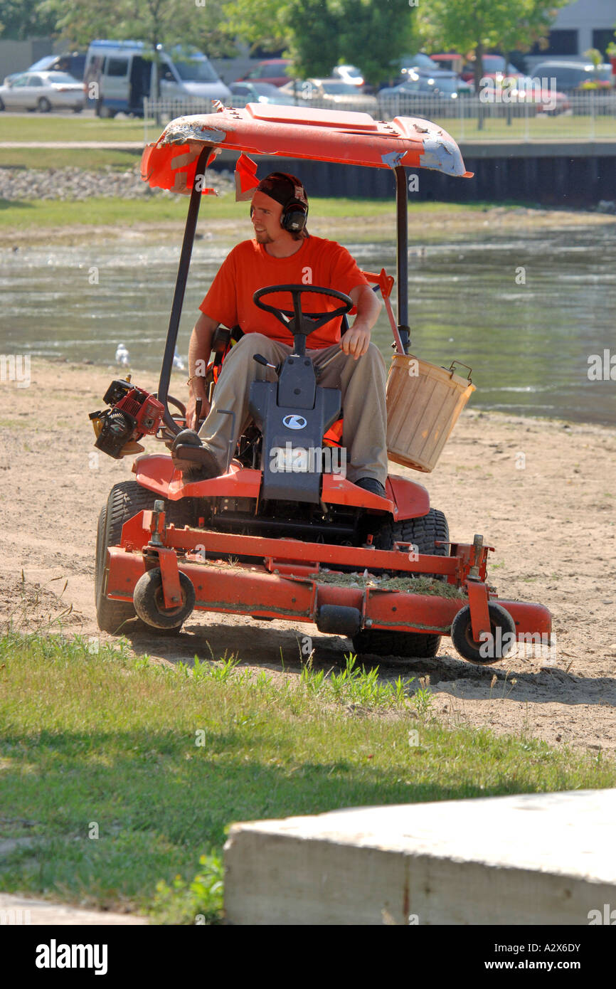 Professional lawncare worker operating a zeroturn mower in a city park Stock Photo Alamy