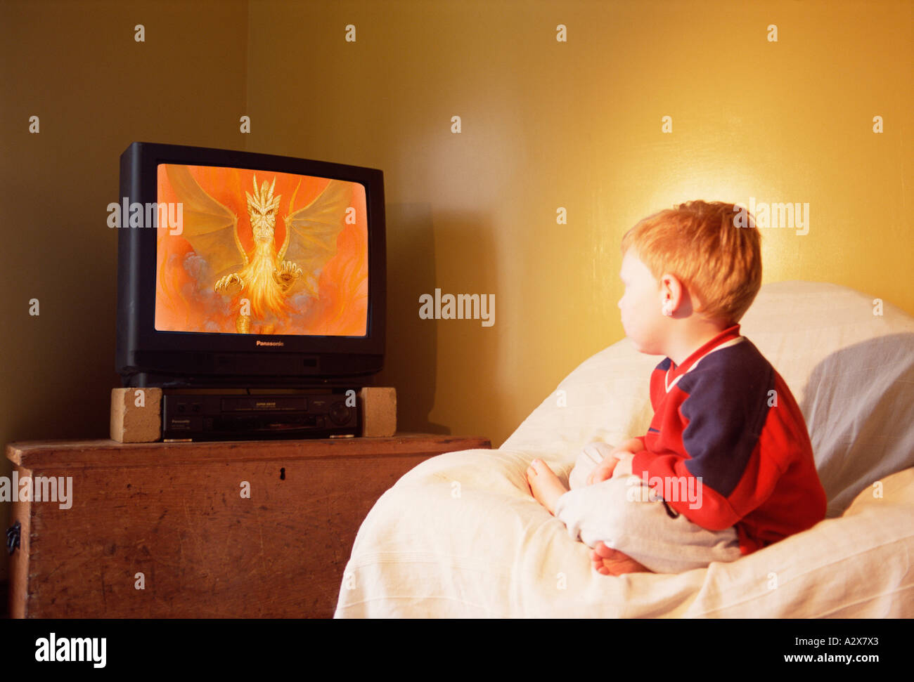 Young boy child indoors watching television. Stock Photo