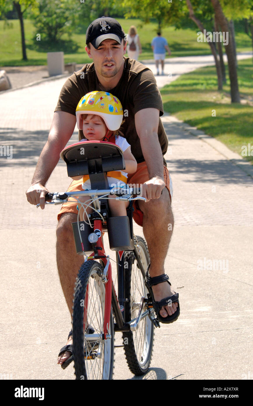 Father and young daughter on a single bicycle Stock Photo
