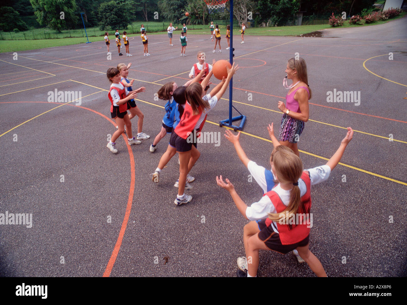 School children playing netball game in outdoors playground. Stock Photo