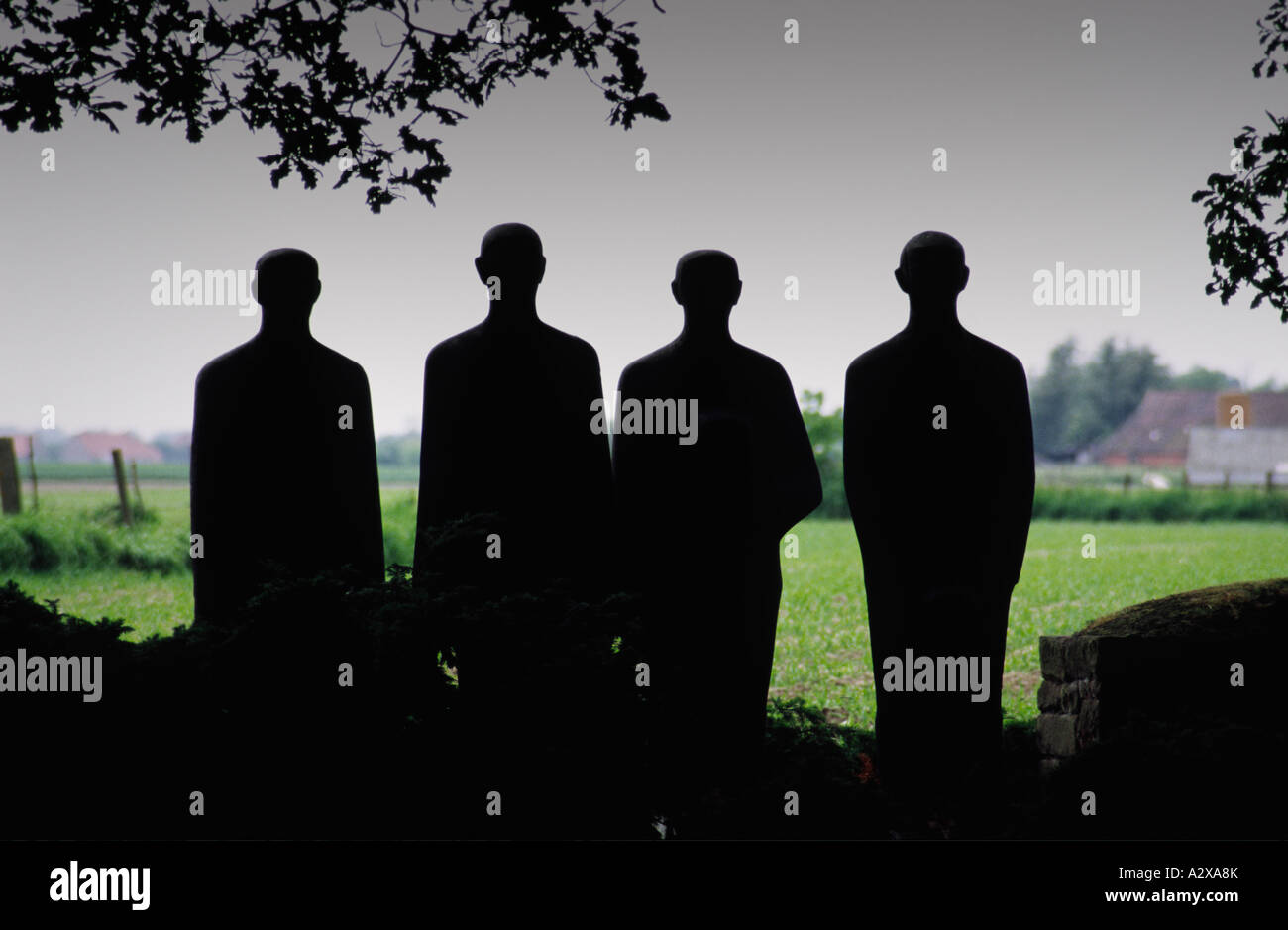 Silhouetted statues in the Langemark German military cemetery Belgium Stock Photo