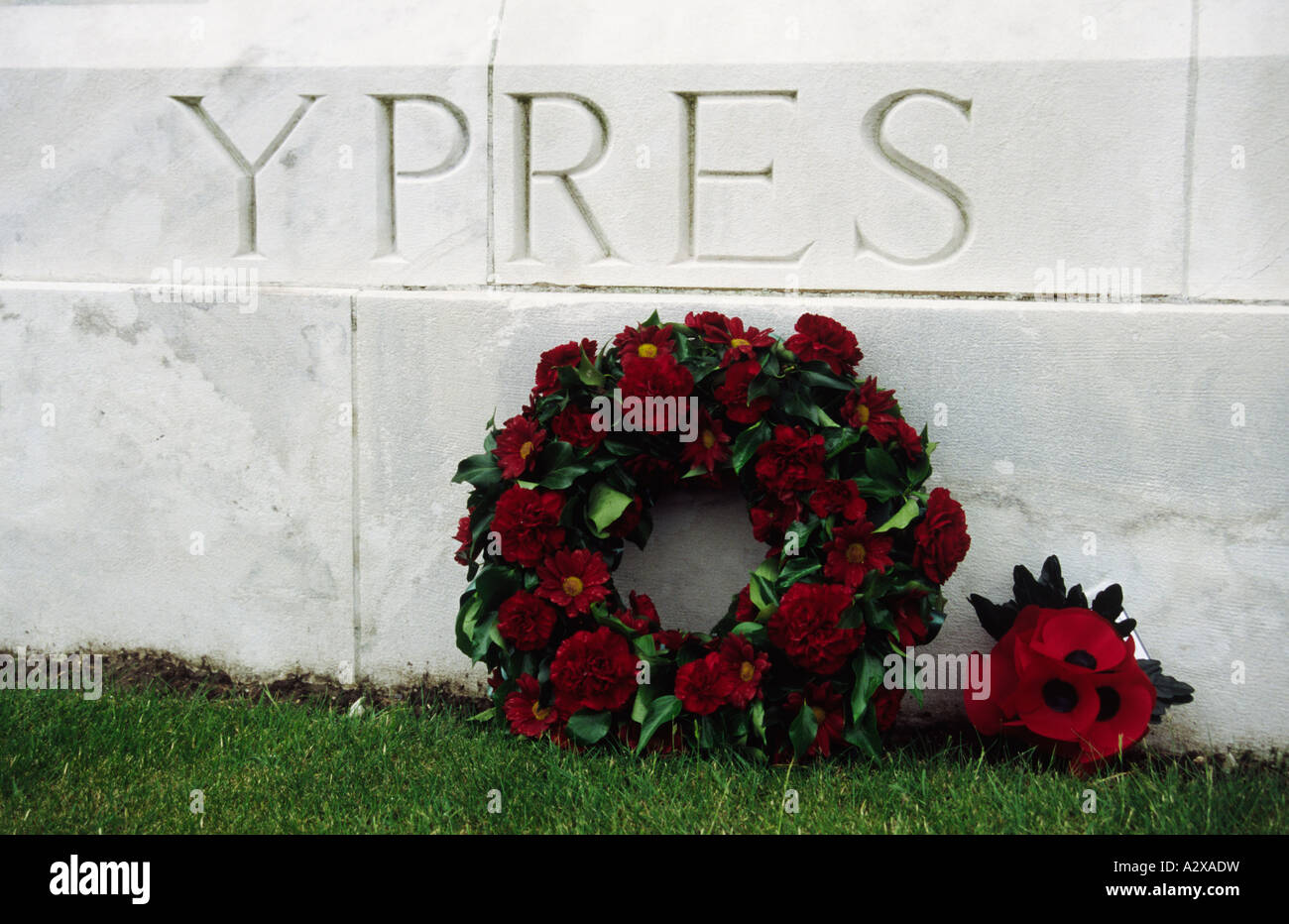 Wreath under the word Ypres carved in stone Tyne Cot British cemetery Belgium Stock Photo