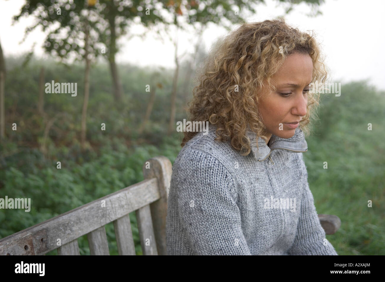 Woman alone on park bench Stock Photo - Alamy