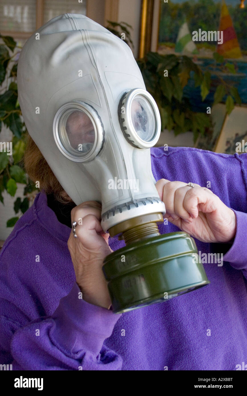 Woman age 67 testing her gas mask survival equipment. Plainfield Illinois USA Stock Photo