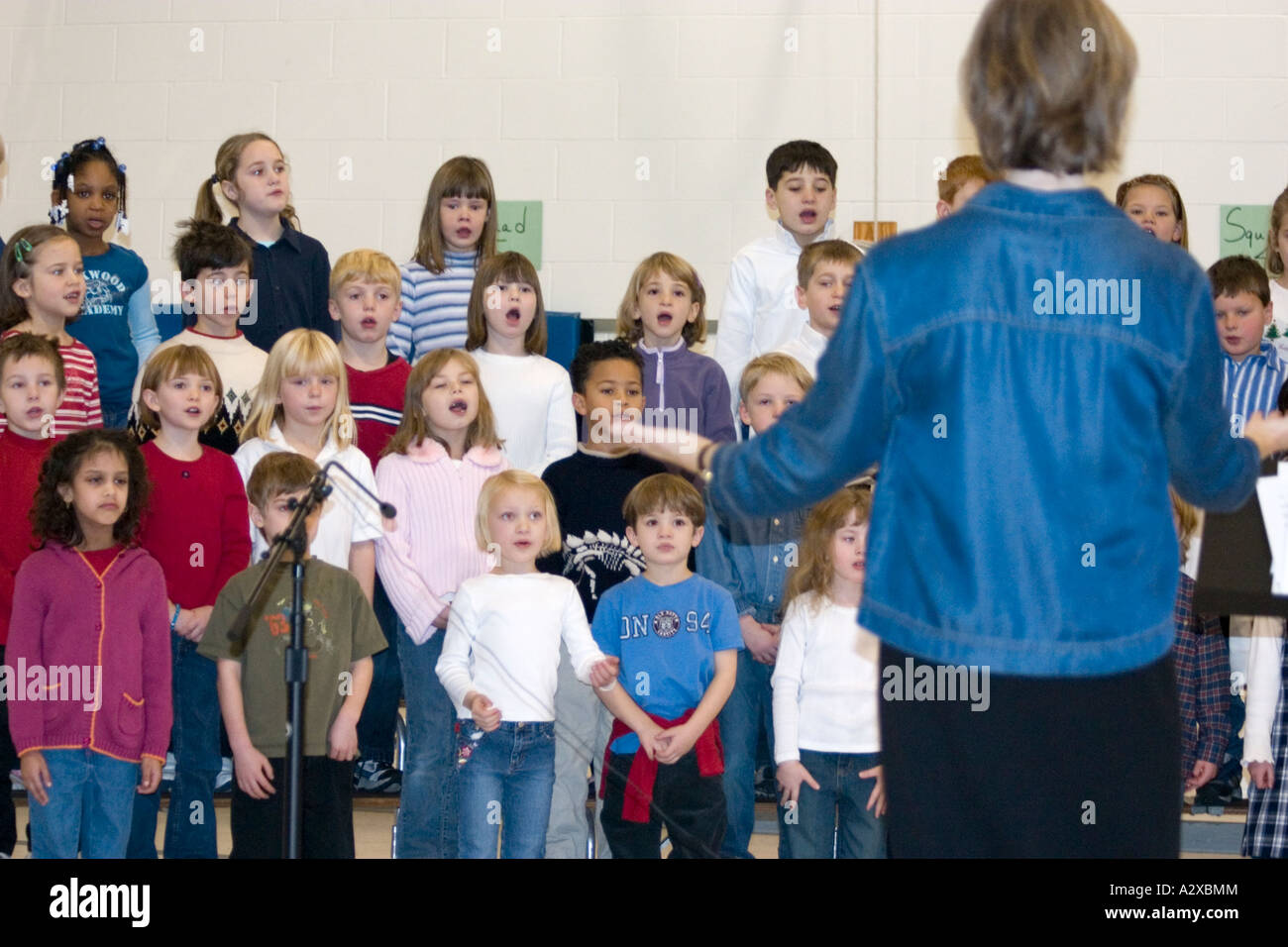 Music director leading children's chorus. Hurricane Katrina benefit concert - Horace Mann School. St Paul Minnesota USA Stock Photo