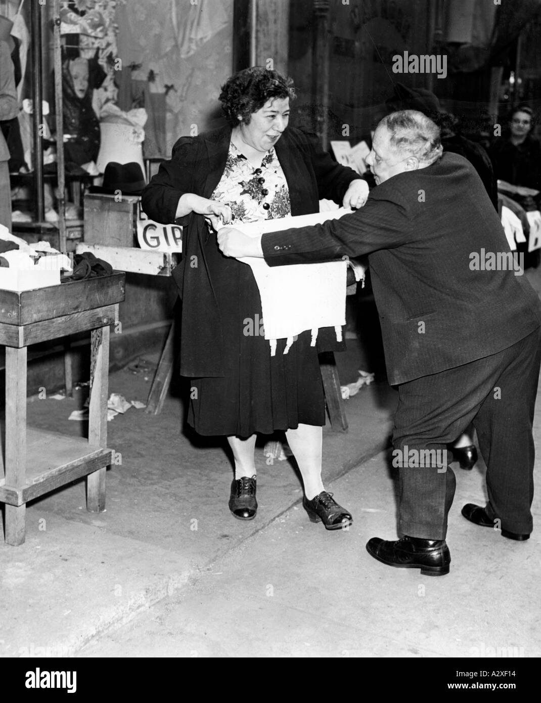 On Orchard Street in New York s Lower East Side street traders sold female customers practically everything from pins to nylons This picture dating from 4 March 1946 shows the unconventional sales practices employed by Mr I Knox who is commending a girdle to Mrs J Schlaeger In der Orchard Street im New Yorker Stadtteil Lower East Side verkaufen die Strassenhaendler ihren weiblichen Kunden von der Stecknadel bis hin zu Nylon Struempfen fast alles Das Bild vom 4 Maerz 1946 zeigt die unkonventionellen Verkaufspraktiken von Mr I Knox der seiner Kundin Mrs J Schaeger einen Hueftguertel anpreist Stock Photo