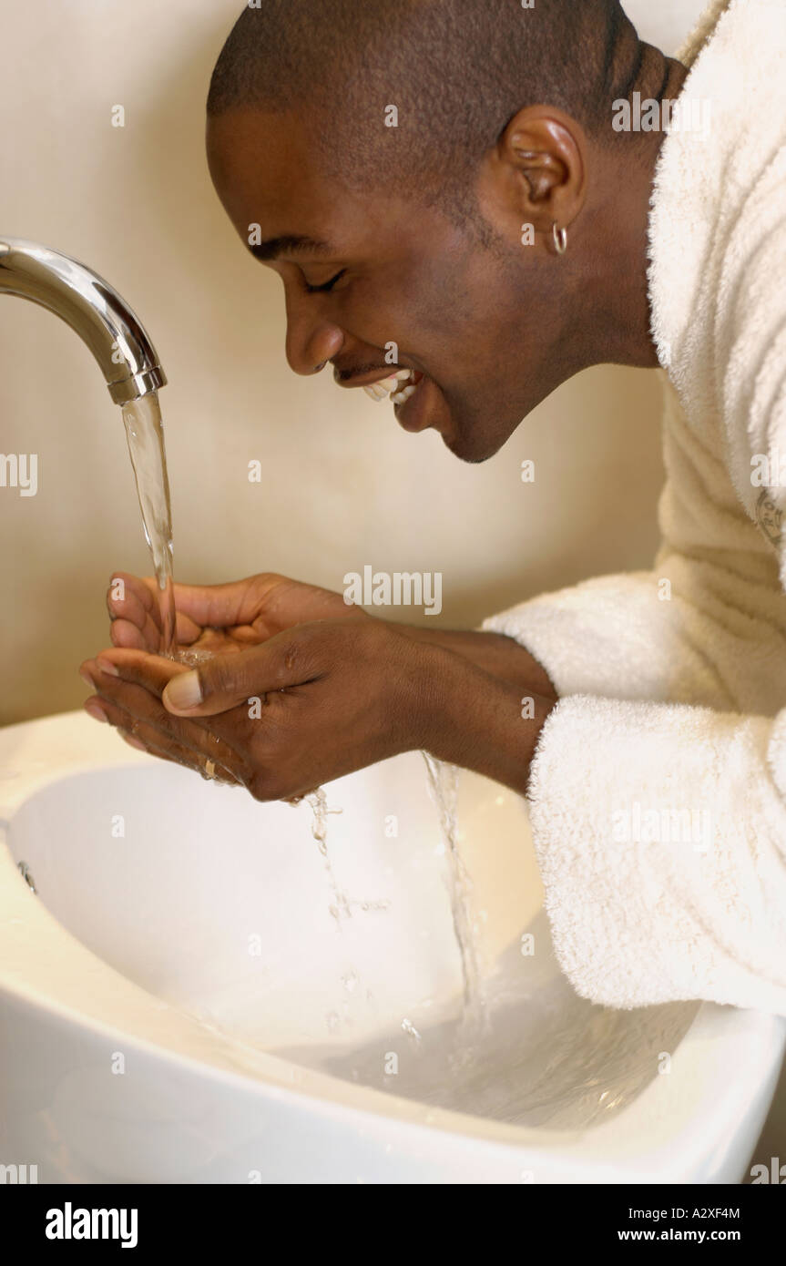 African man washing face in sink Stock Photo Alamy