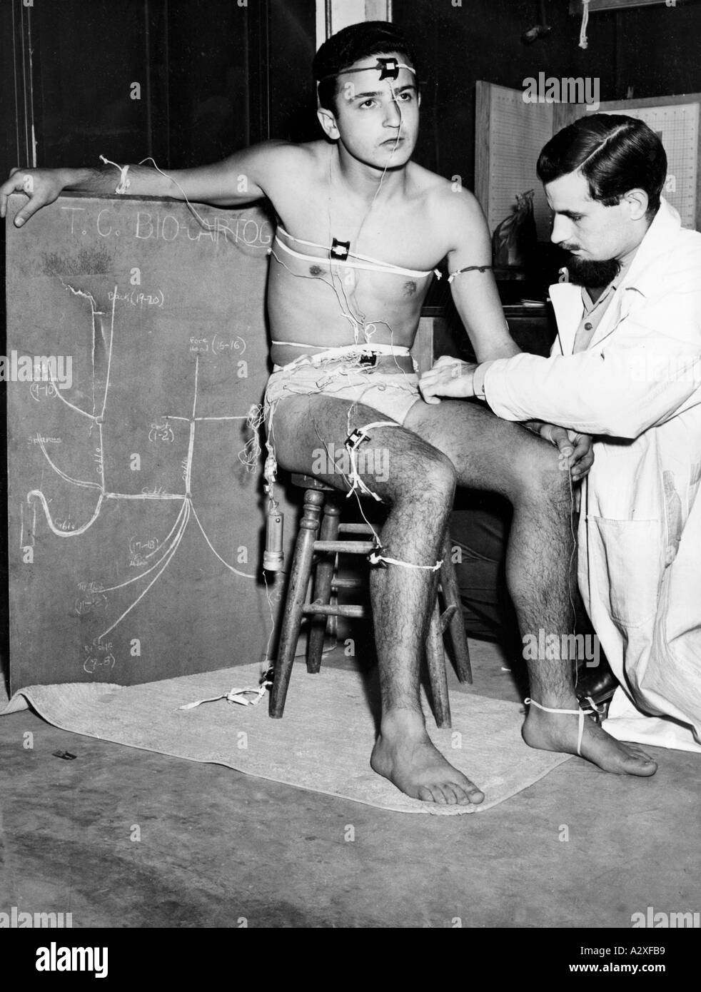 In 20th century medicine everything is measurable Beneath the caption Supersonic Sizzle these two pictures report on temperature measurements taken on students at the University of California in Los Angeles in August 1948 Before the student is placed in the Hot Box sensors are attached to certain parts of his skin as for an electro cardiogram In der Medizin des 20 Jahrhunderts ist alles messbar Unter der Ueberschrift Ueberschall Brutzeln berichten diese beiden Bilder ueber Temperaturmessungen an Studenten der University of California in Los Angeles im August 1948 Bevor der Student in die Hot Stock Photo