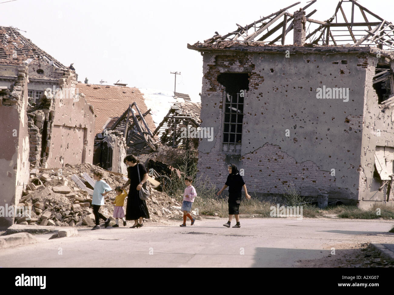 Vukovar, Croatia, under Serb control,  Feb 1992: Women and children walk through the rubble.  15,000 people still live here. Stock Photo