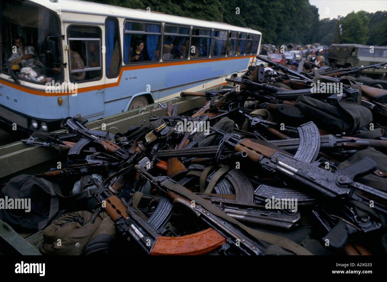 Croatian re-capture of Krajina, Aug 95: A bus of Serb refugees passes a truck full of AK 47s surrendered by Krajina Serbs. Stock Photo