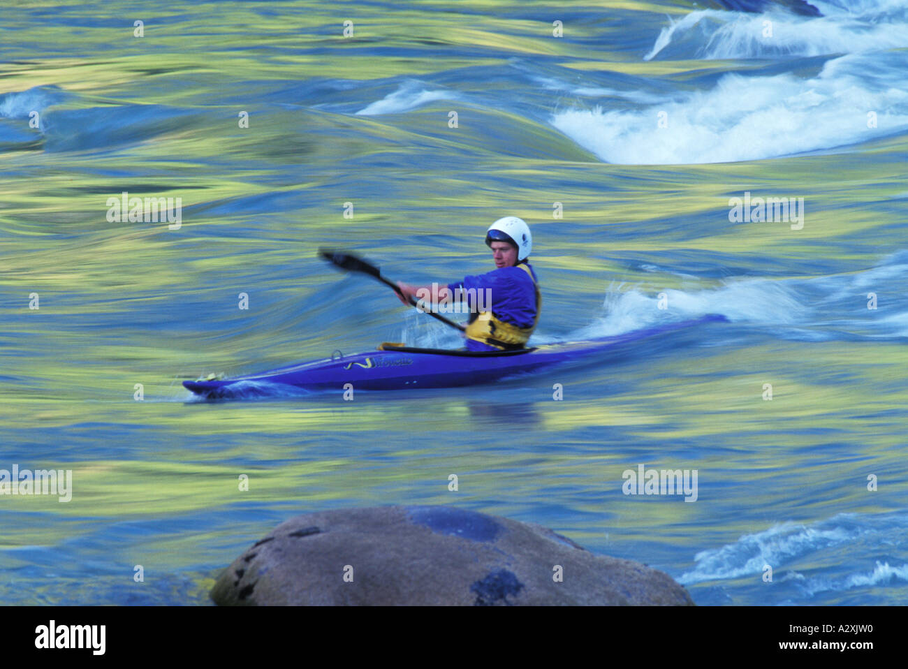 CHILE Kayaker paddling through silky yellow and blue water BIO BIO River Stock Photo