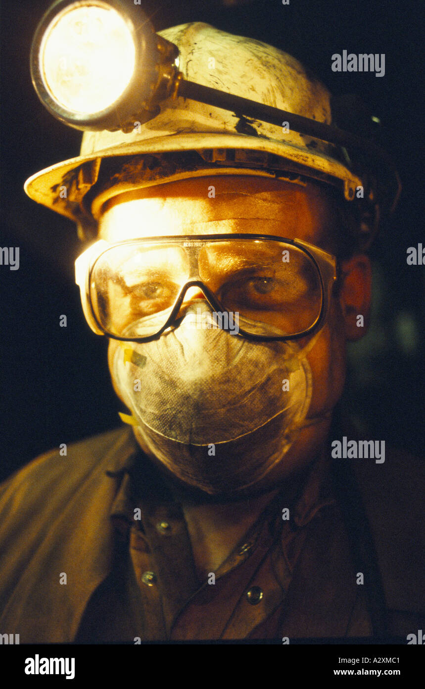 COALMINER IN DARKNESS, WEARING GOGGLES, MASK & HELMET WITH HEAD TORCH