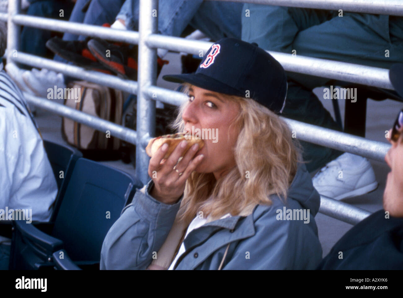 Girl eating hot dog at baseball game. Stock Photo
