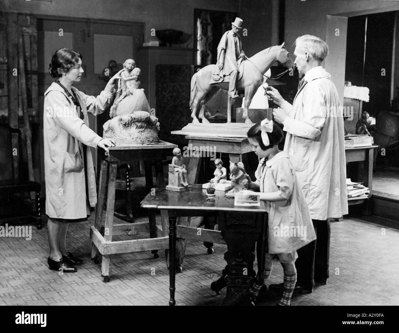 The Torreys and their 7 year old daughter are seen keeping up the good old tradition of realistic sculpture in the Art Colony at the University of Chicago The caption to this picture dated 29 March 1928 stresses the fact that the parents were artists of repute and that art dominated the life of the family Das Ehepaar Torrey und seine siebenjaehrige Tochter pflegen die gute alte Tradition der realistischen Skulptur in der Kuenstlerkolonie an der Universitaet von Chicago Die Bildunterschrift vom 29 Maerz 1928 betont dass die Eltern renommierte Kuenstler seien und Kunst ihr Familienleben Stock Photo