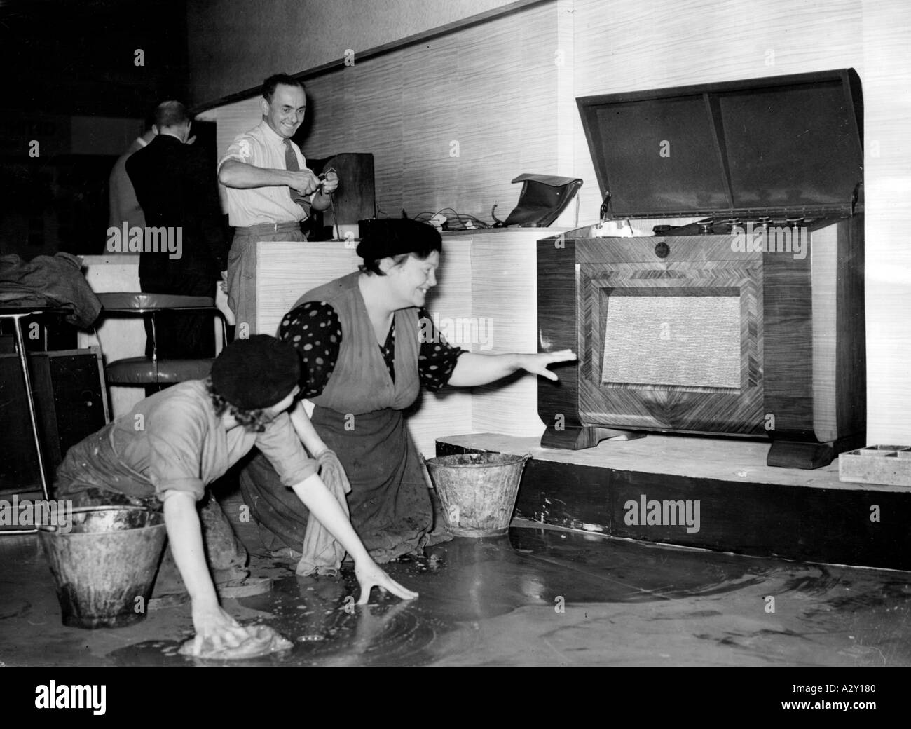 The 1938 Radio Exhibition at London s Olympia showed the latest achievements in the field both of the wireless and of television and this at amazing prices One of the exhibits is seen here providing two charwomen with music while they work Die Radioausstellung im Londoner Olympia 1938 zeigt die neuesten Errungenschaften auf den Gebieten der Audio und Television und dies zu erstaunlichen Preisen Die beiden abgebildeten Putzfrauen steigern ihre Arbeitslaune durch die Klaenge eines Ausstellungsstueckes Curious Moments S 482 Stock Photo