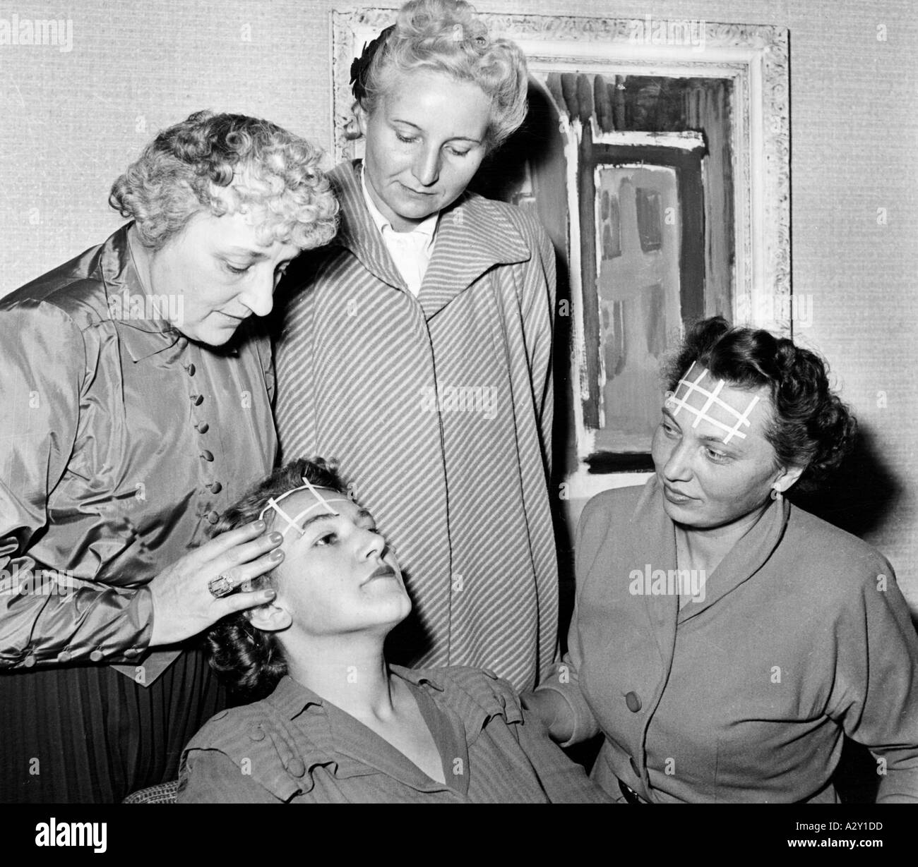 These Berlin housewives are receiving cosmetic instruction from France in 1952 At the foundation course run by a specialist from Paris the ladies are learning all about make up French style Here Madame is seen revealing the secret of removing unwanted wrinkles from the brow Kosmetische Nachhilfe aus Frankreich erhalten 1952 diese Berliner Hausfrauen Im Grundkurs der Expertin aus Paris erfahren die Damen alles ueber das Make up im franzoesischen Stil Hier verraet Madame das Geheimnis mit dem sie unerwuenschte Stirnfalten beseitigt Curious Moments S 557 Stock Photo