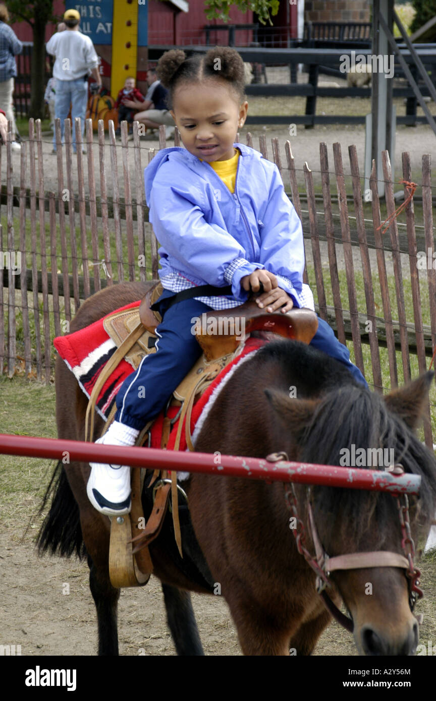 Child riding on a pony for fun and pleasure stock photo alamy