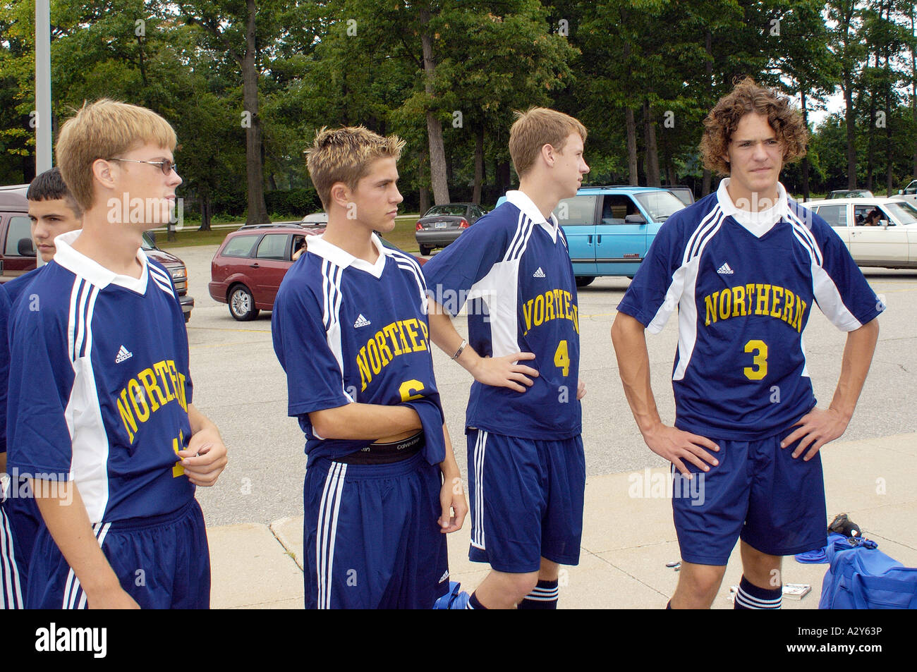 A team of soccer teammates stand around talking and socializing with one another Stock Photo