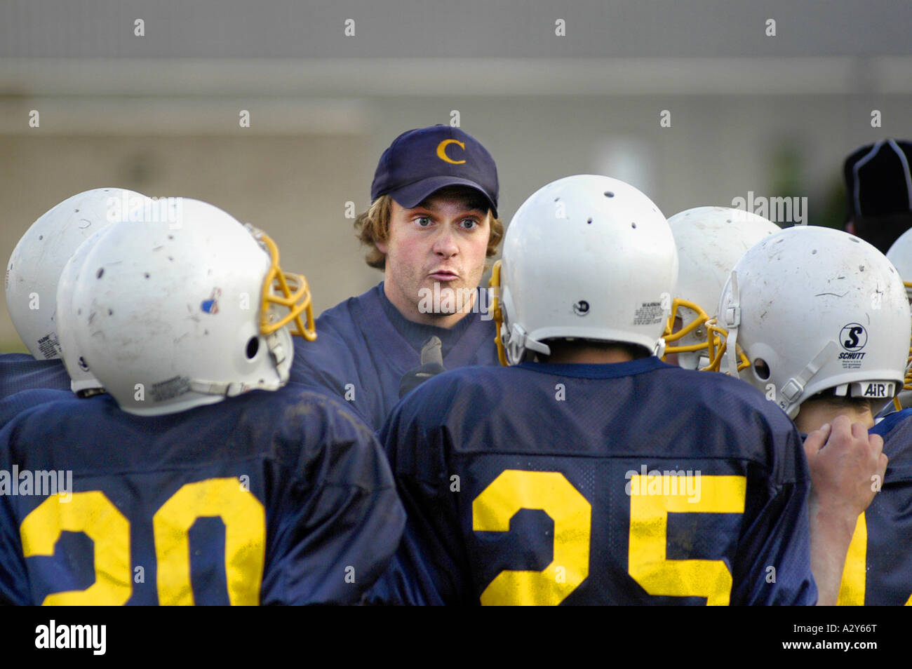 Middle school football action with coach talking strategy with the team Stock Photo