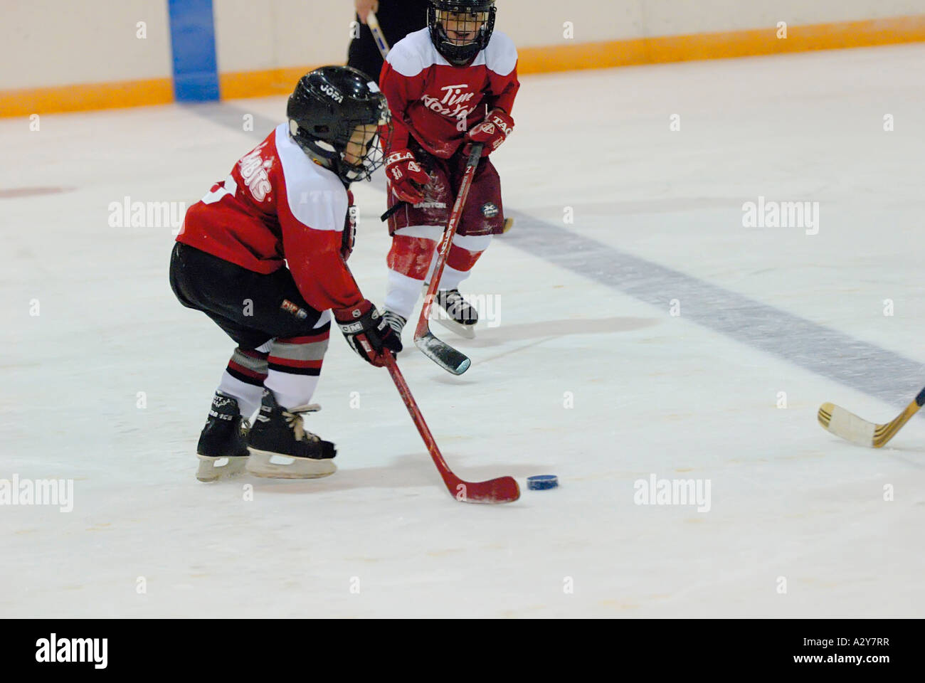 5 and 6 year old children learn how to play the game of ice hockey