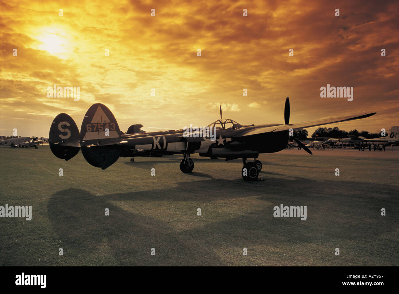 The sun sets over a USAAF P 38 Lightning at Duxford Airfield Cambridge England Stock Photo