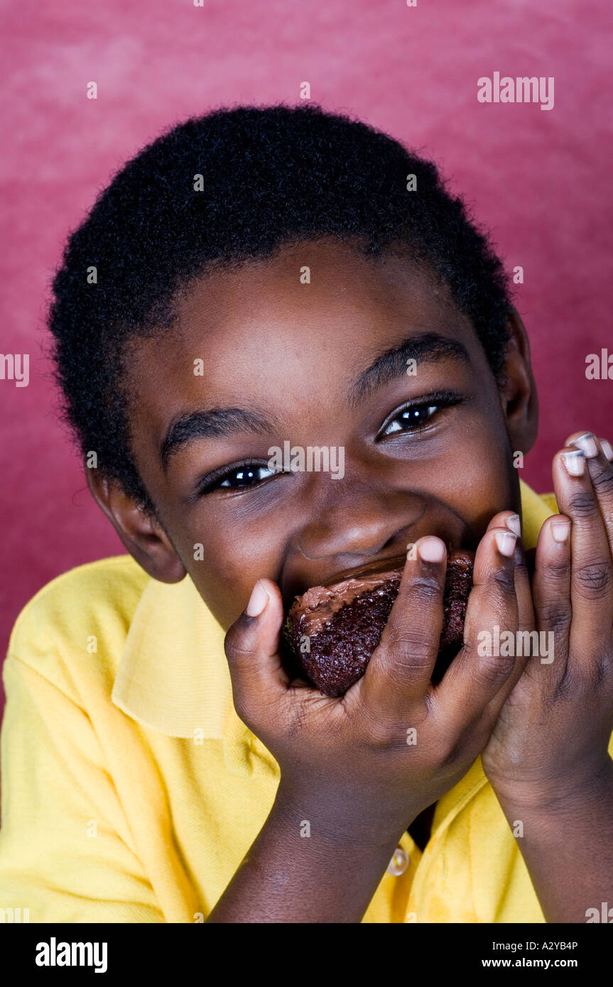 African American kid eating chocolate cake Stock Photo