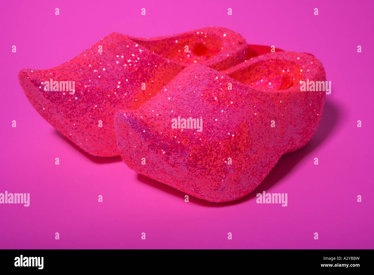 A pair of sparkling pink Clogs on a pink background Stock Photo Alamy