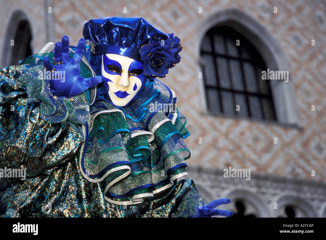 A Jester in Blue and Green Entertains in San Marco at Carnevale in Venice, Italy Stock Photo