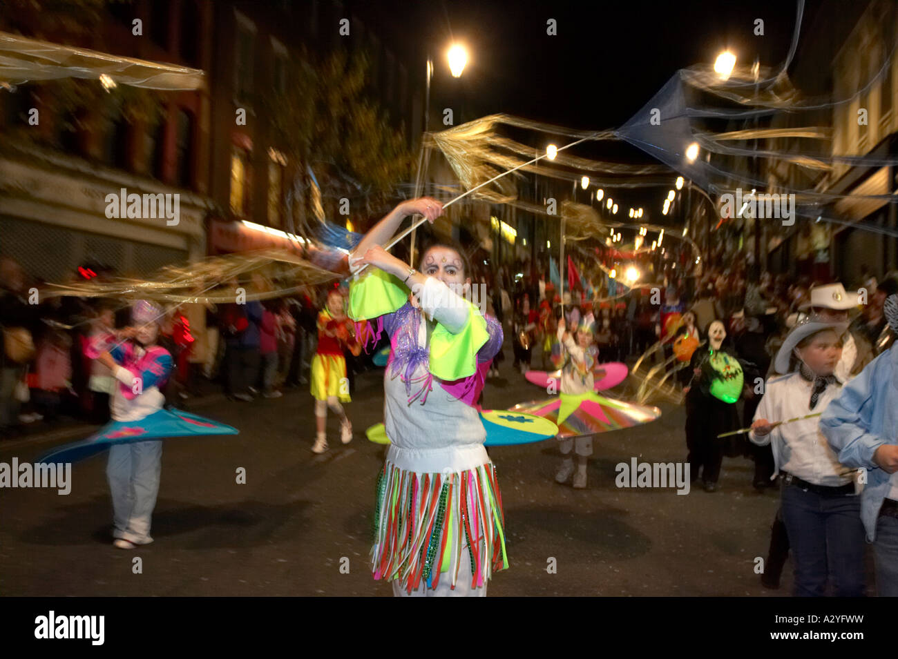 children in colourful costumes with streamers parade down shipquay street Halloween Derry Ireland Stock Photo