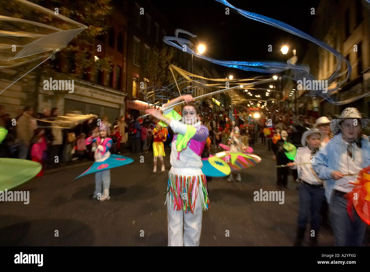 children in colourful costumes with streamers parade down shipquay