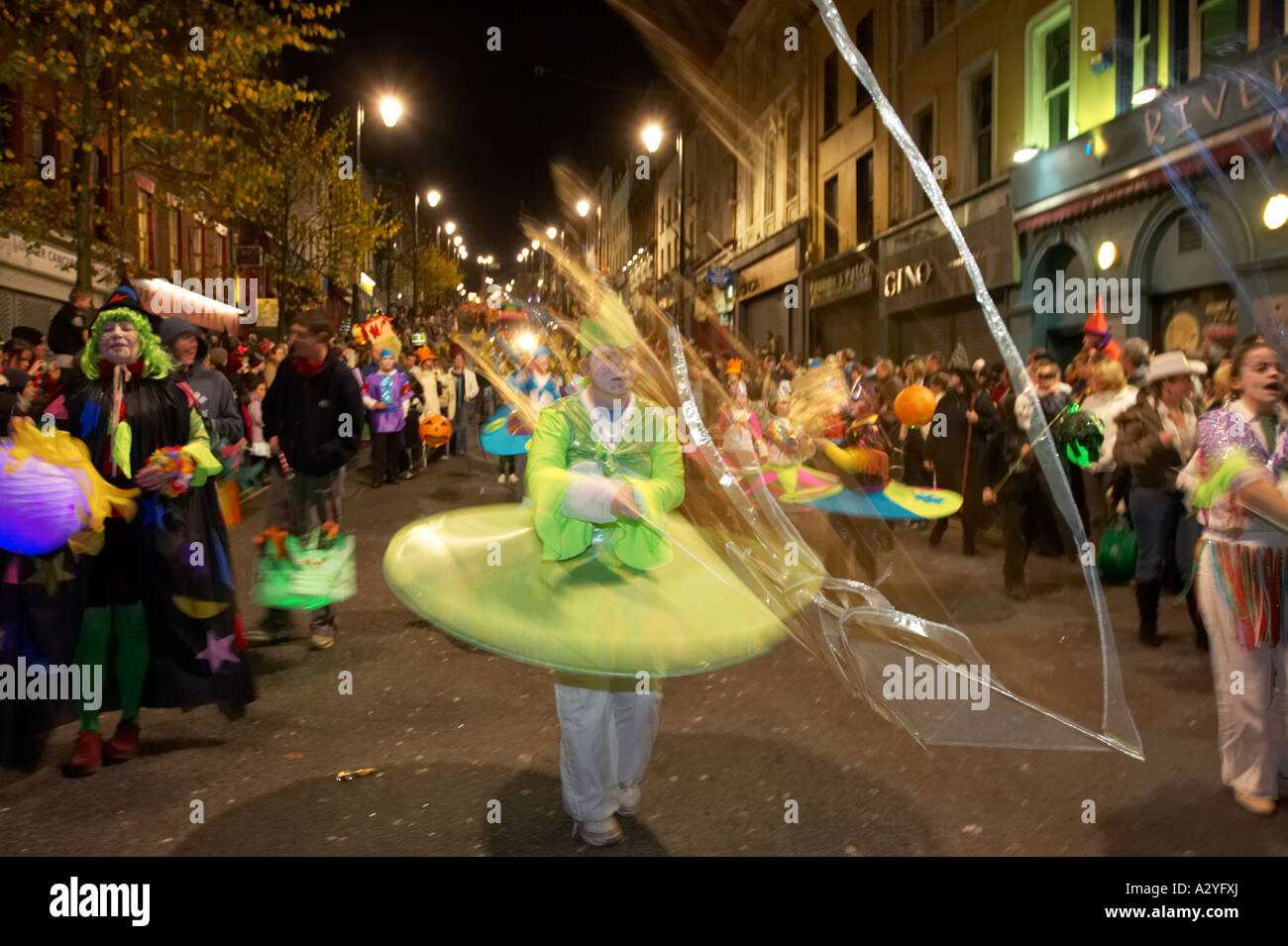 children in colourful costumes with streamers parade down shipquay street Halloween Derry Ireland Stock Photo