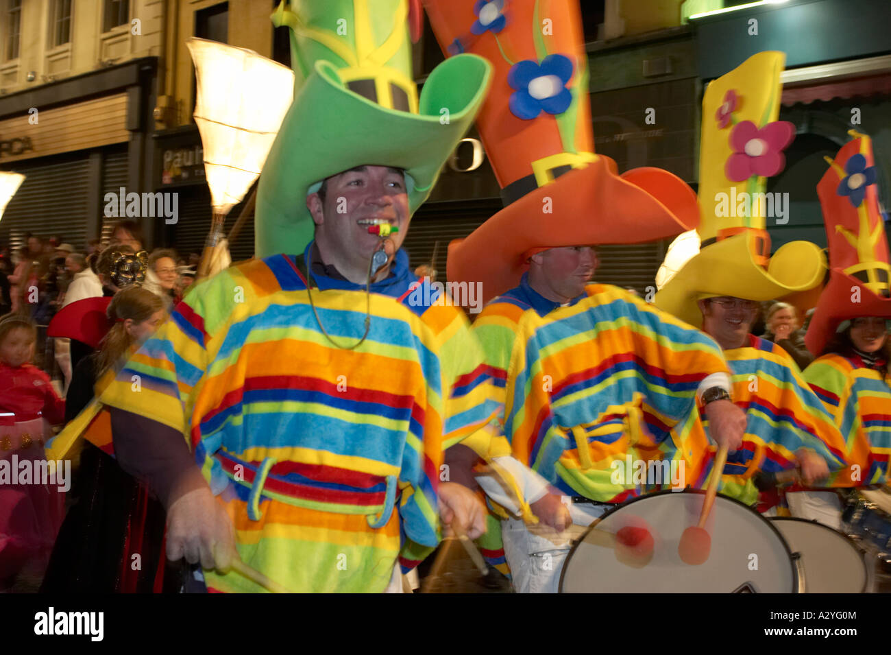 male percussion drum band dressed as colourful mexicans with large hats walk down shipquay