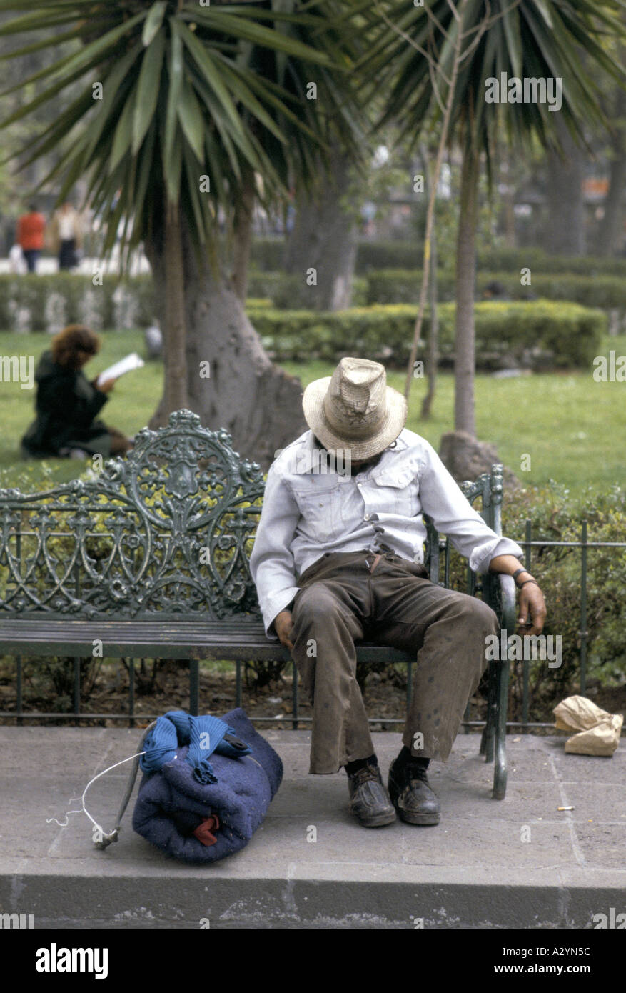 homeless sat asleep on a bench mexico city Stock Photo