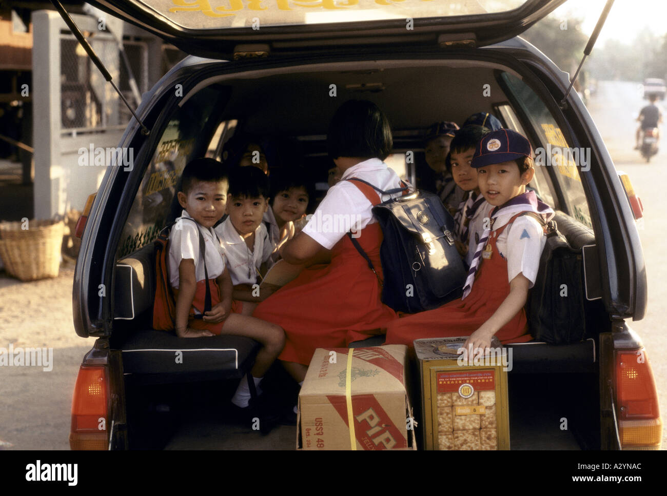 Children in the back of a car ready to be driven to school in Bangkok, Thailand Stock Photo