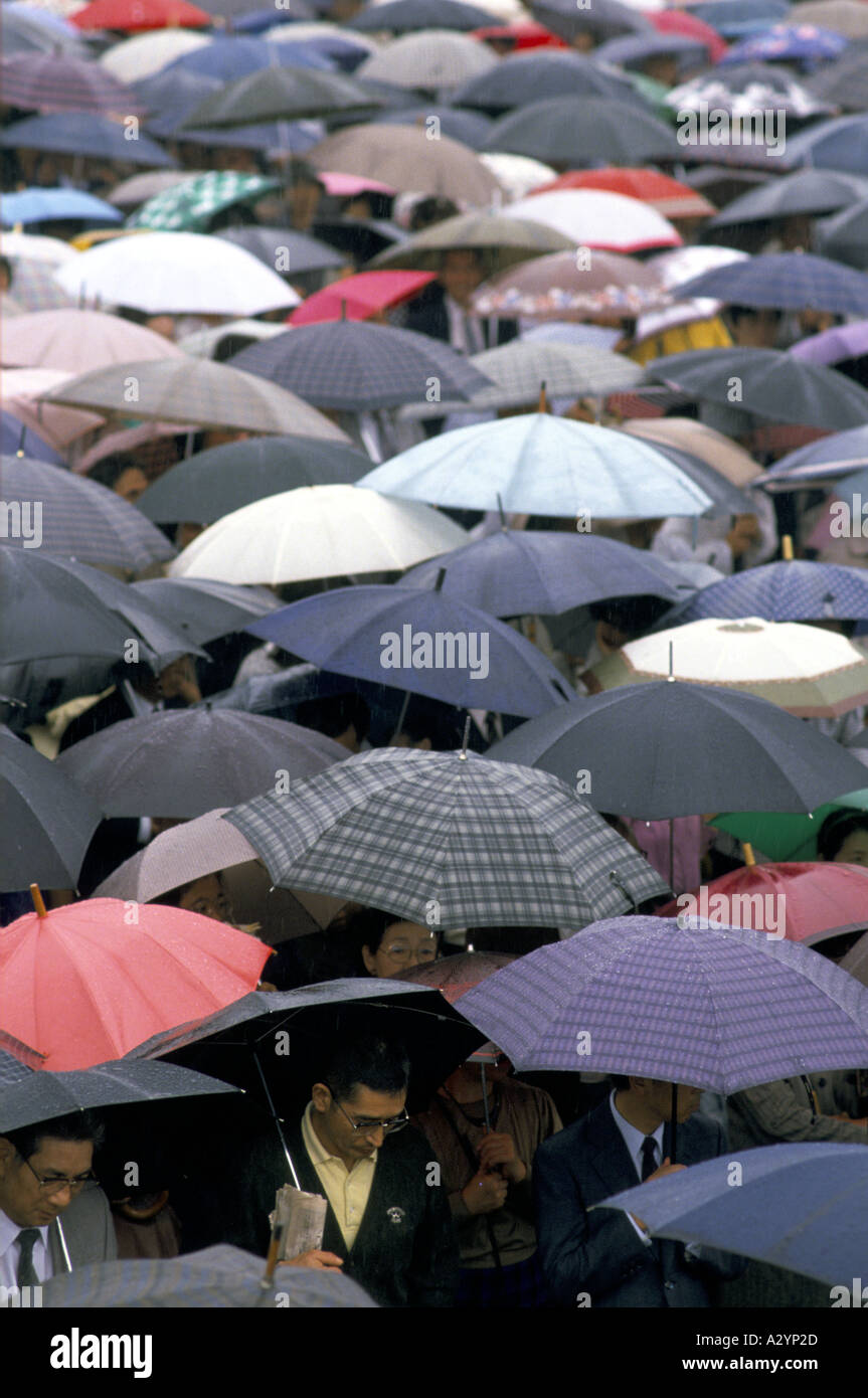 A closely backed sea of umbrellas protect a crowd of people from the rain in Tokyo Stock Photo