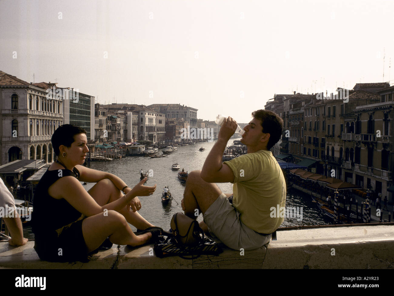 people drinking water on a bridge overlooking venice Stock Photo