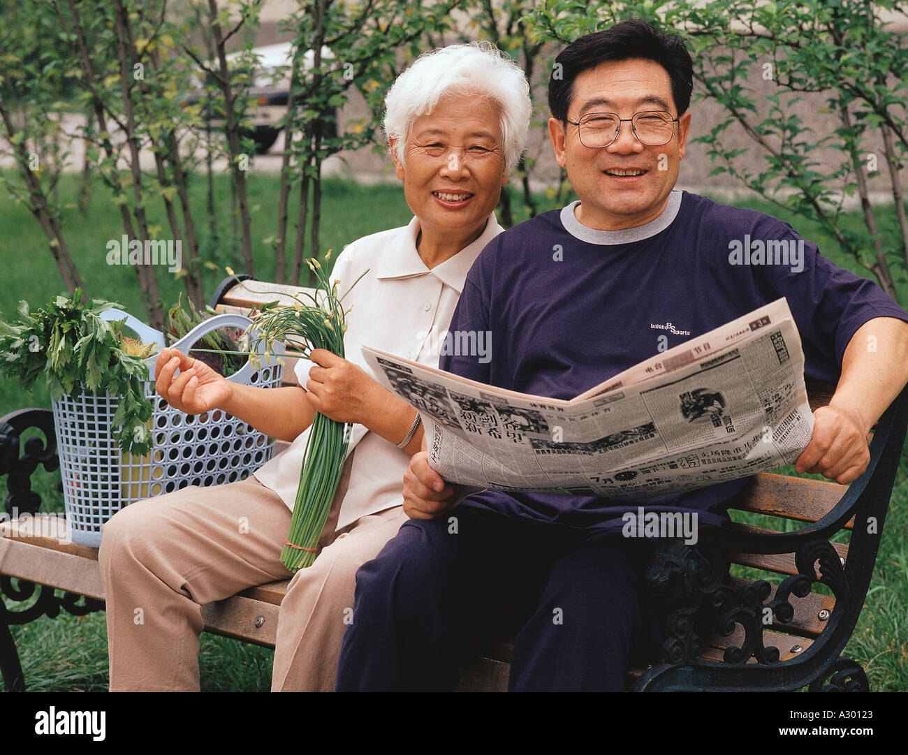 Chinese happy mature couple sitting on a bench Stock Photo - Alamy