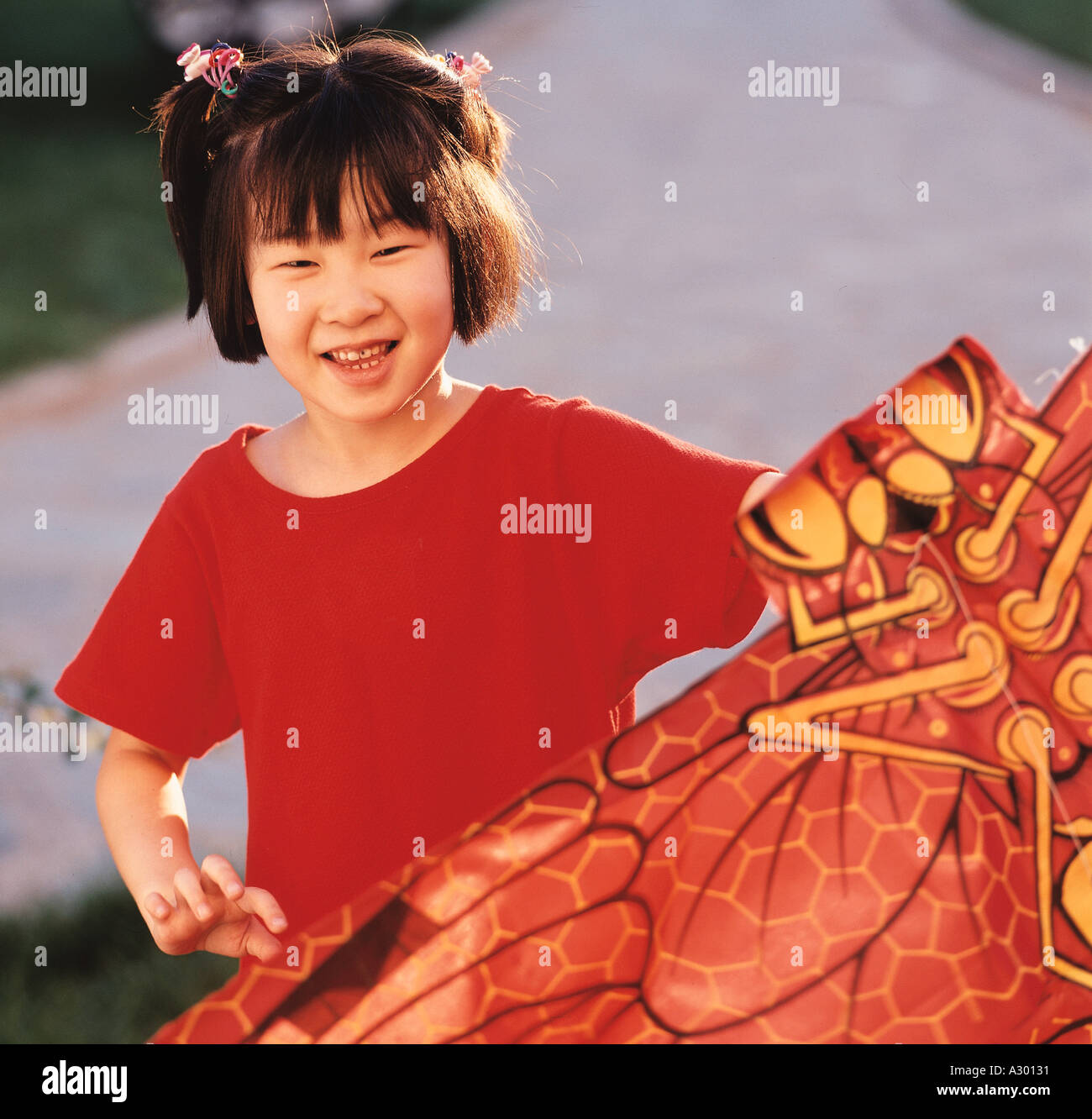 a chinese six year old girl holding a red dragonfly kite Stock Photo