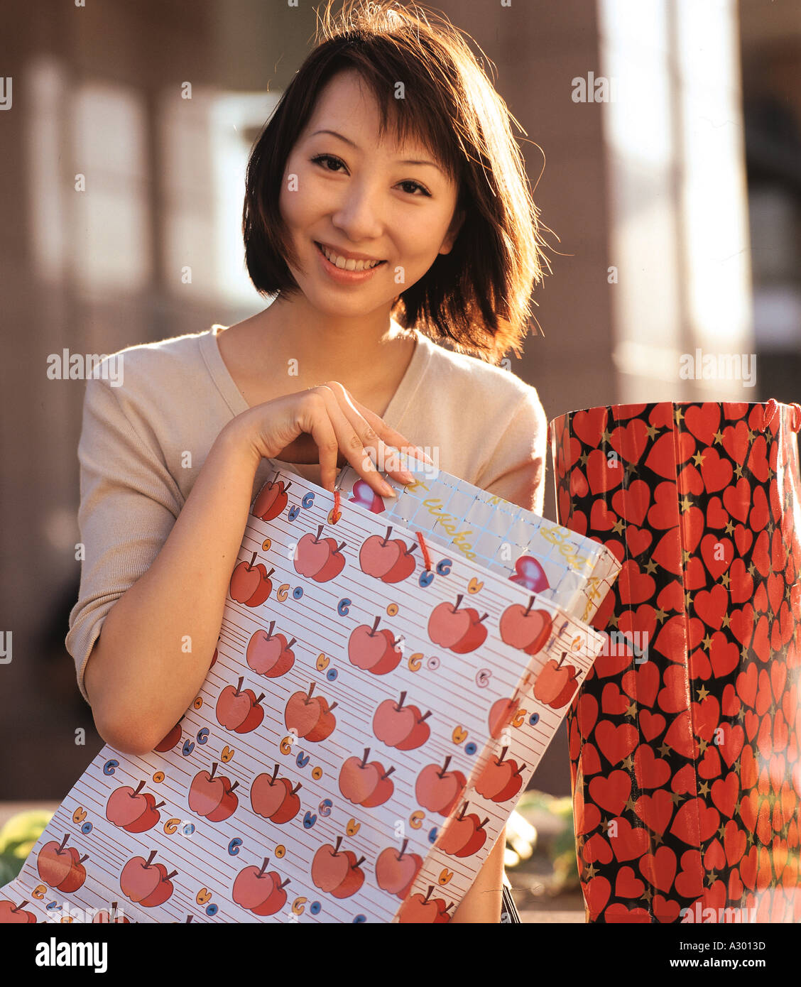 a chinese young woman holding shopping bags and smiling Stock Photo Alamy