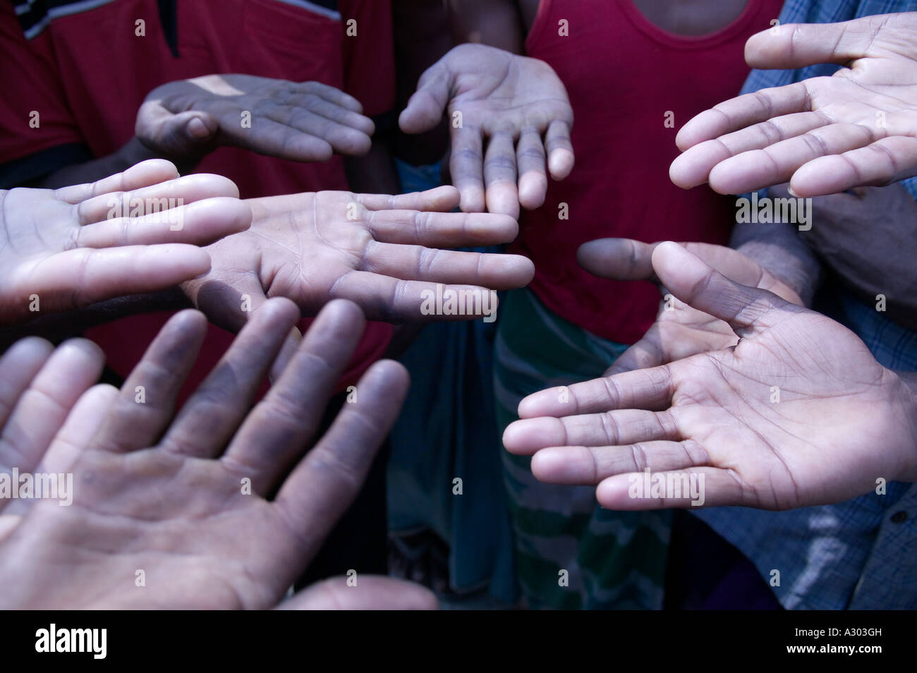 Men at a brick making factory compare hands for callouses Bangladesh Stock Photo