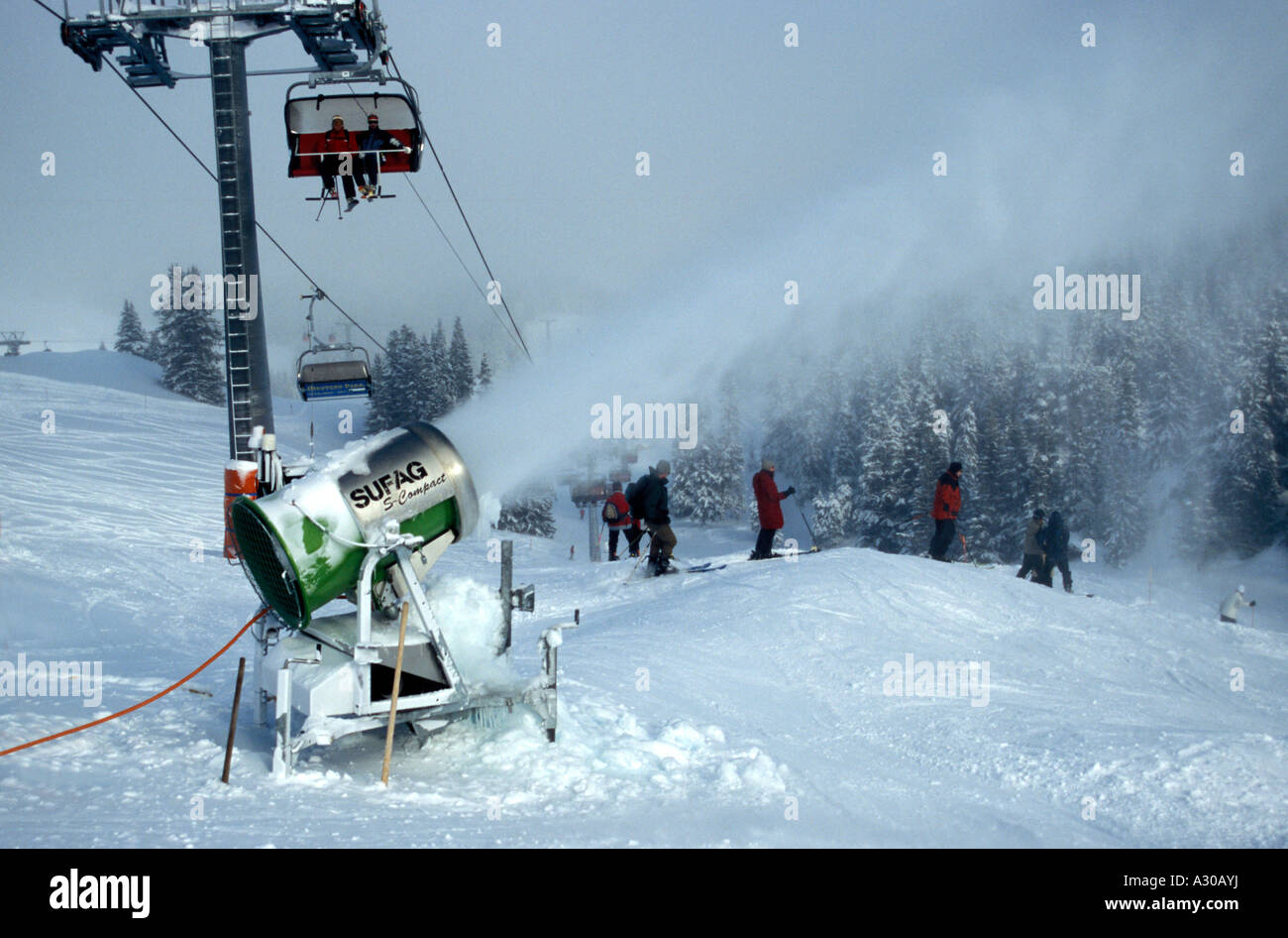 Snow cannon gun, artificial snow making machine on the slopes of a ski  resort, ski lift and piste Stock Photo - Alamy